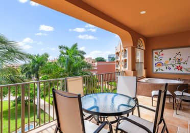 Garden-view balcony with dining set and soaking tub.