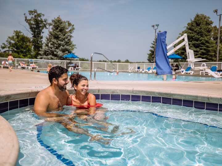 Couple sitting in outdoor pool at Fox River Resort in Sheridan, Illinois.