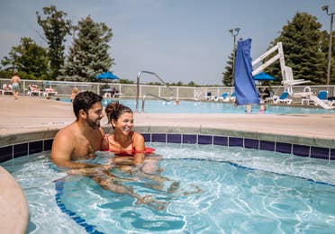 Couple sitting in outdoor pool at Fox River Resort in Sheridan, Illinois.