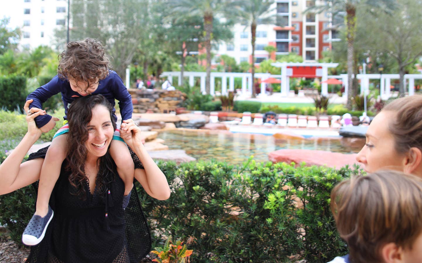 Young child on shoulders of mom exploring River Island at Orange Lake Resort near Orlando, Florida