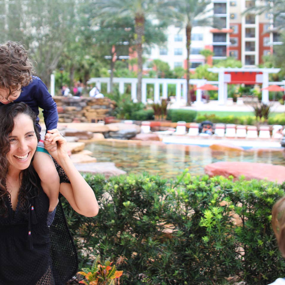 Young child on shoulders of mom exploring River Island at Orange Lake Resort near Orlando, Florida