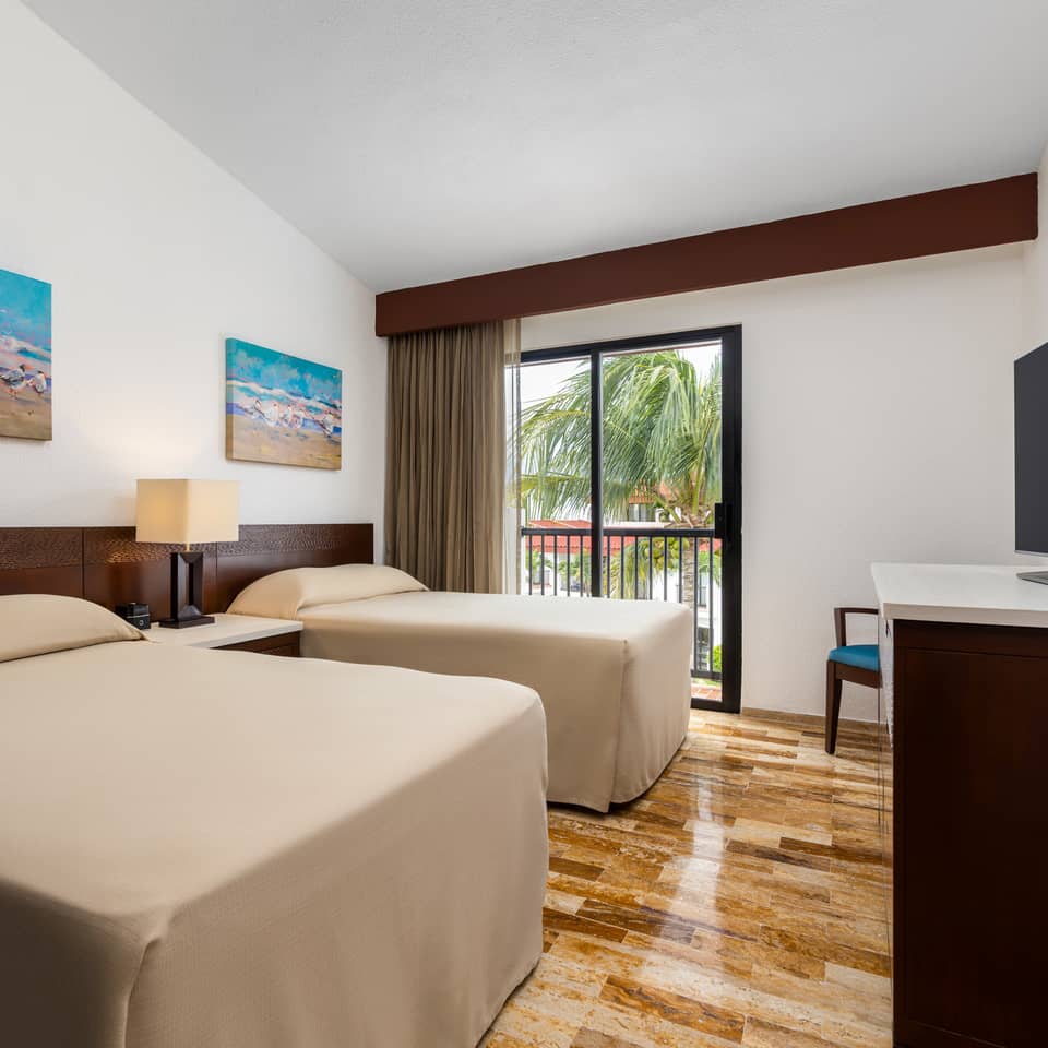 Modern bedroom with two twin beds, a window, and coastal artwork.
