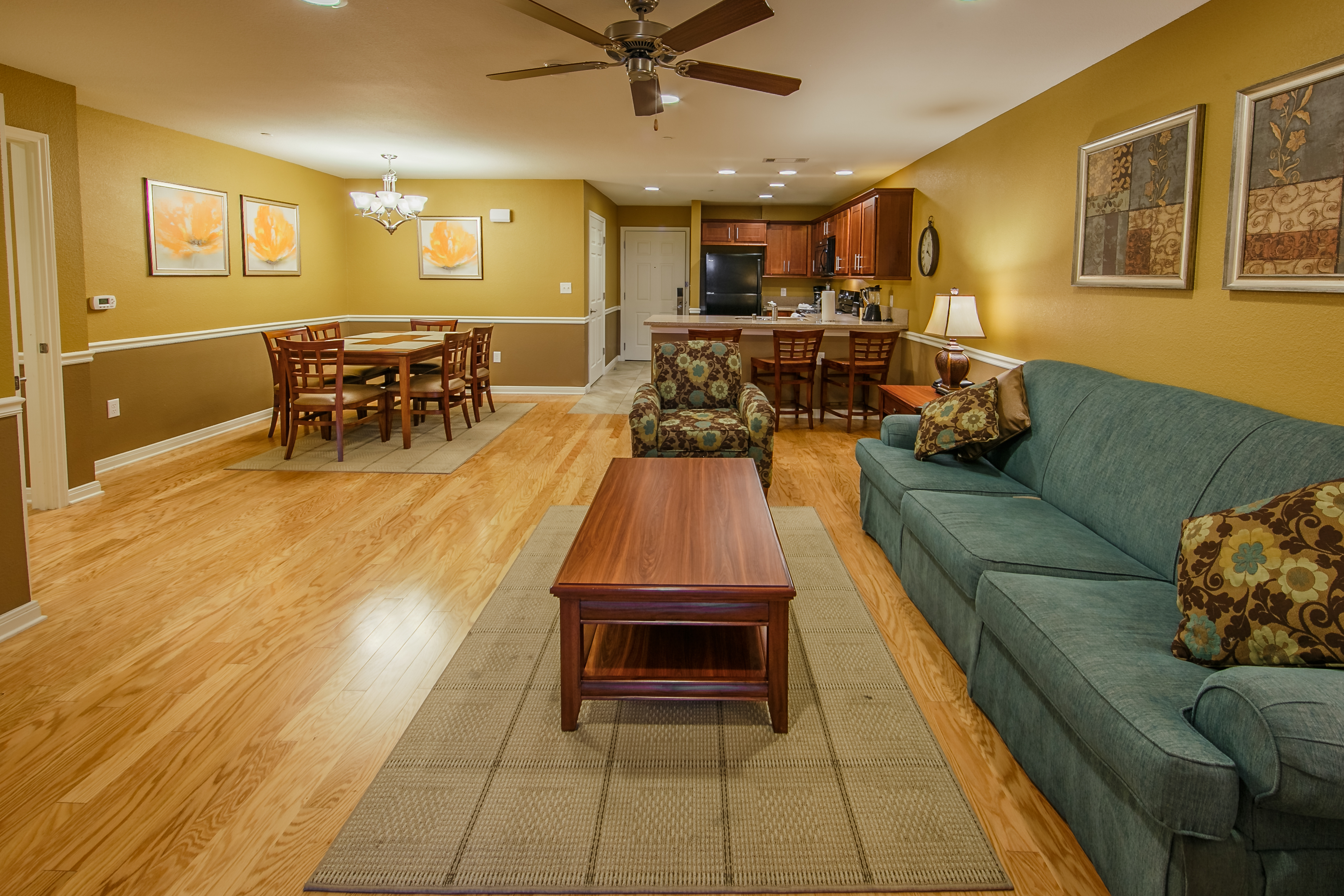 Living room with dining area and kitchen in the background of a two-bedroom ambassador villa at the Hill Country Resort in Canyon Lake, Texas.