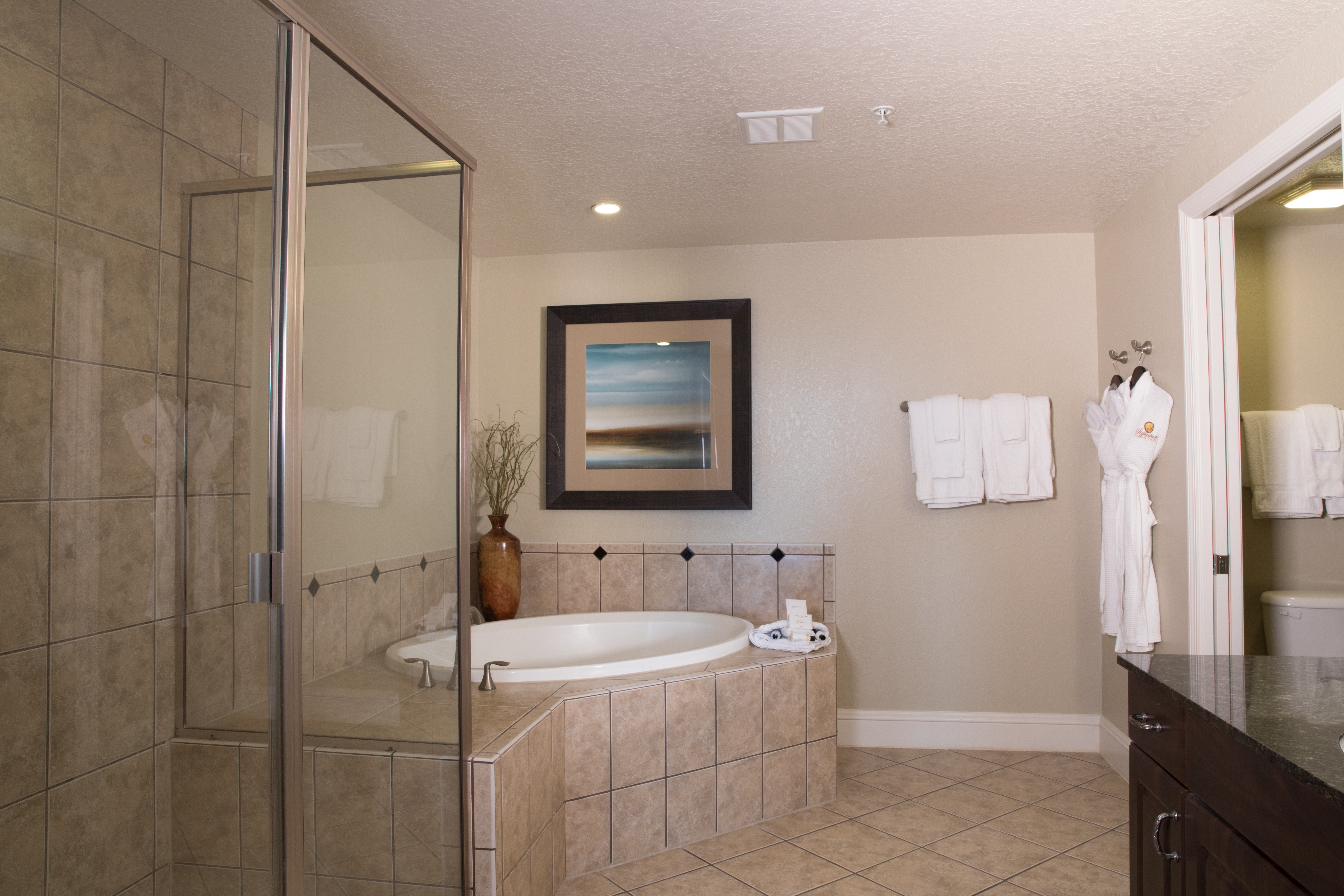 Bathroom with soaking tub, walk-in shower, and complimentary robes in a four bedroom Signature villa in River Island at Orange Lake Resort near Orlando, Florida