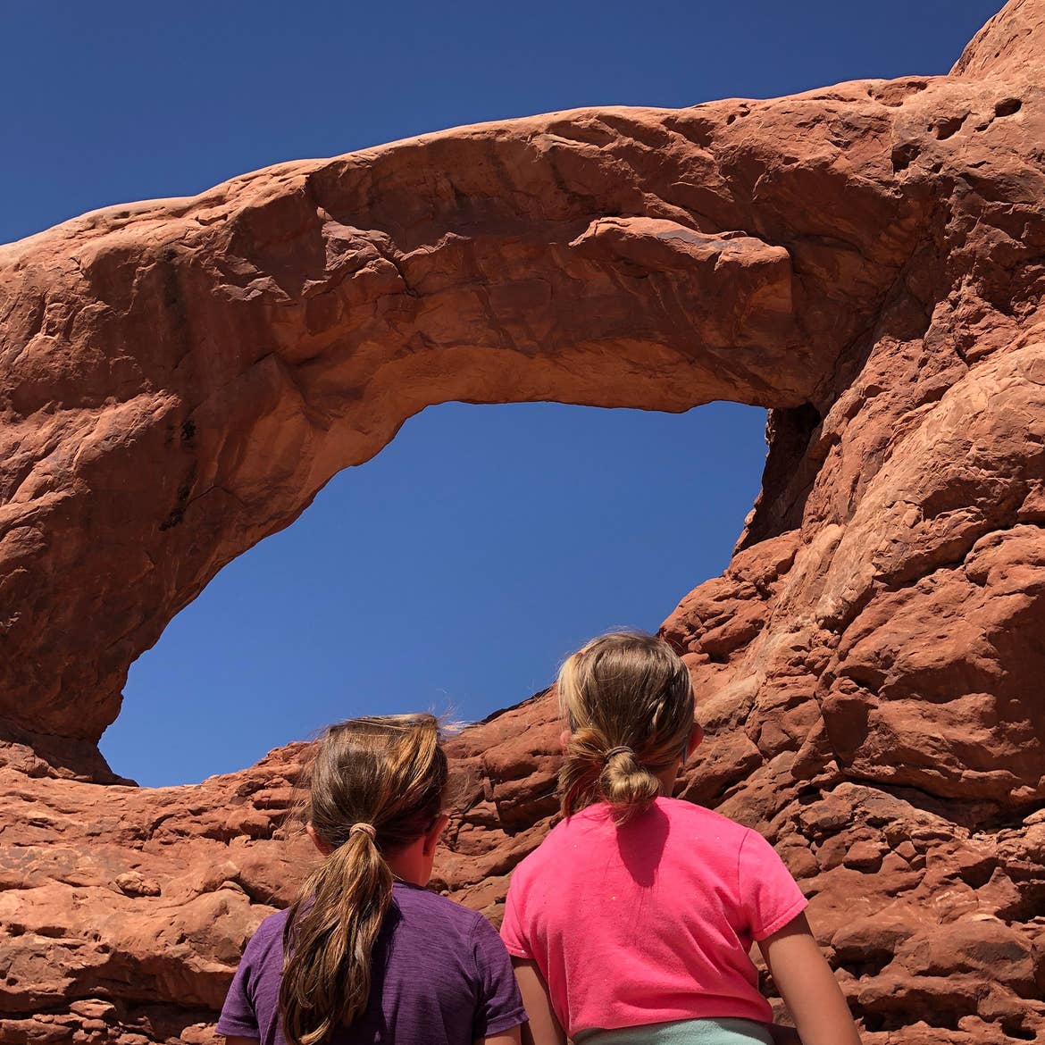 Kyndall and Kyler stand in front of the Delicate Arch.