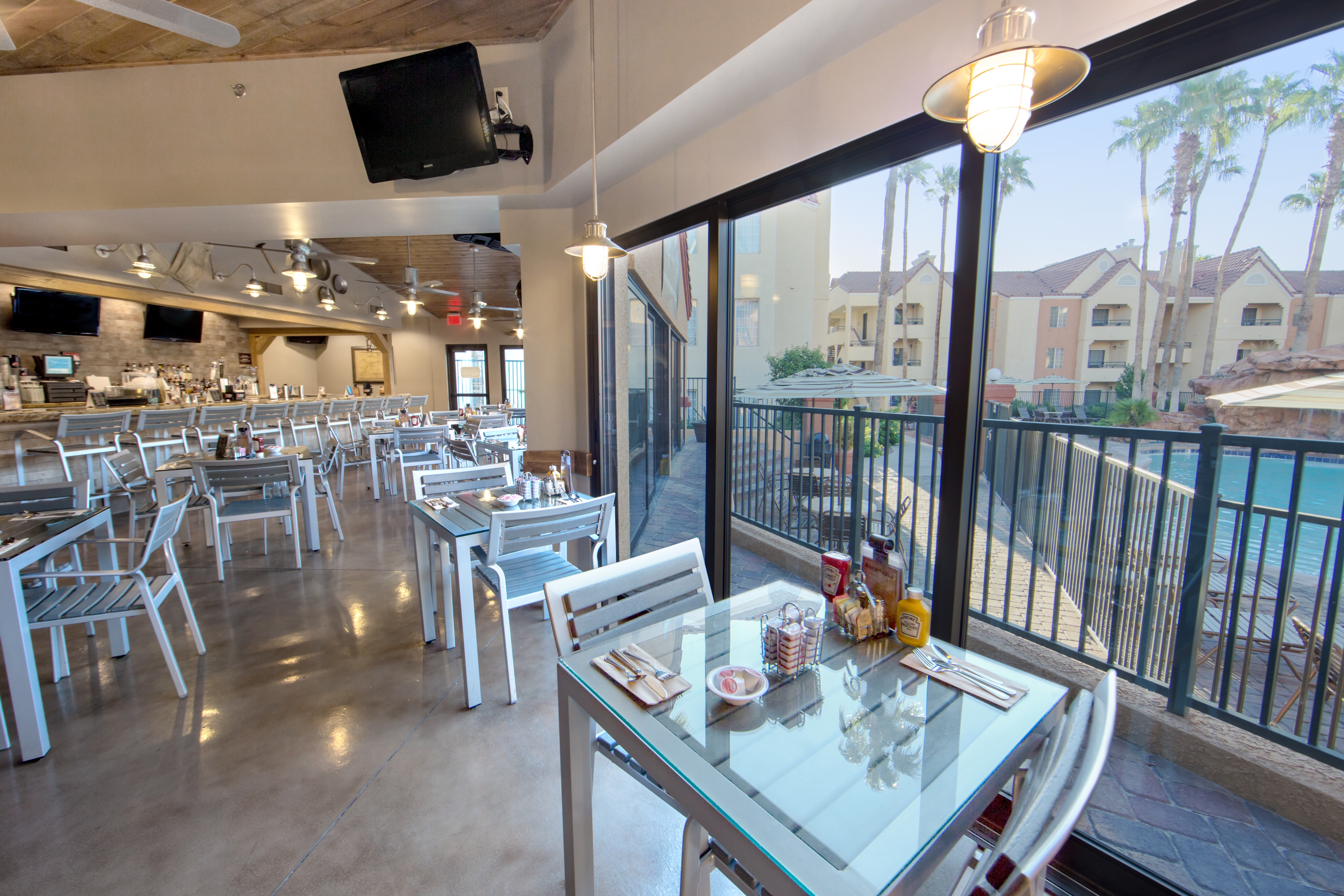 Gold Mine Bar & Grill indoor seating with a view of the pool at Desert Club Resort in Las Vegas.
