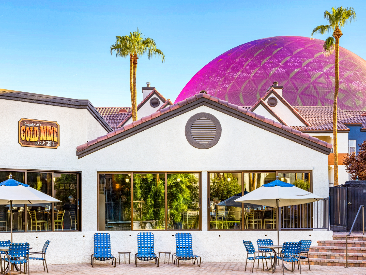 Gold Mine Bar & Grill exterior with Sphere behind and interior seating with a view of the pool at Desert Club Resort in Las Vegas.