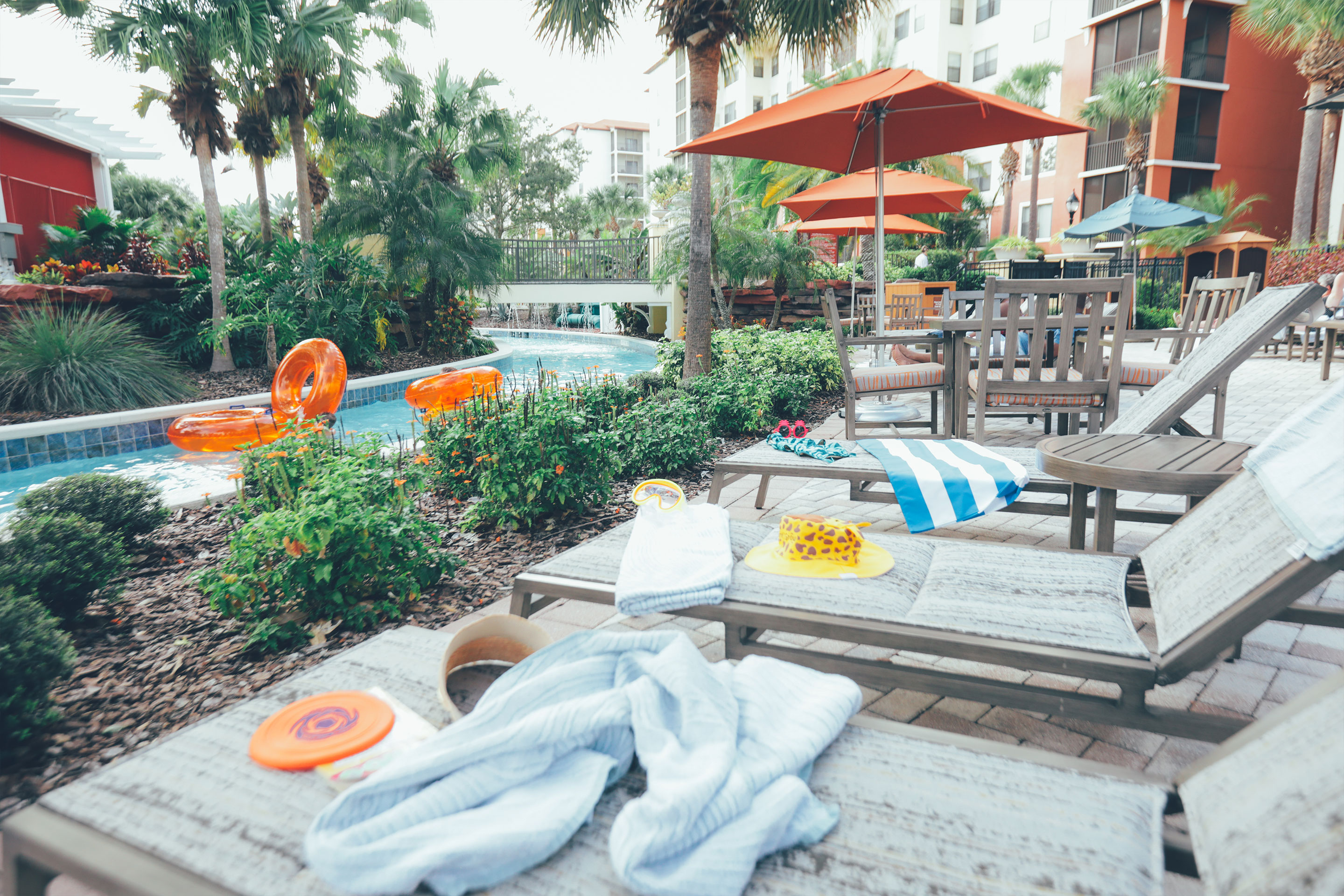 Beach chairs with swimming toys and towels placed next to our lazy river at Orange Lake Resort in Florida.