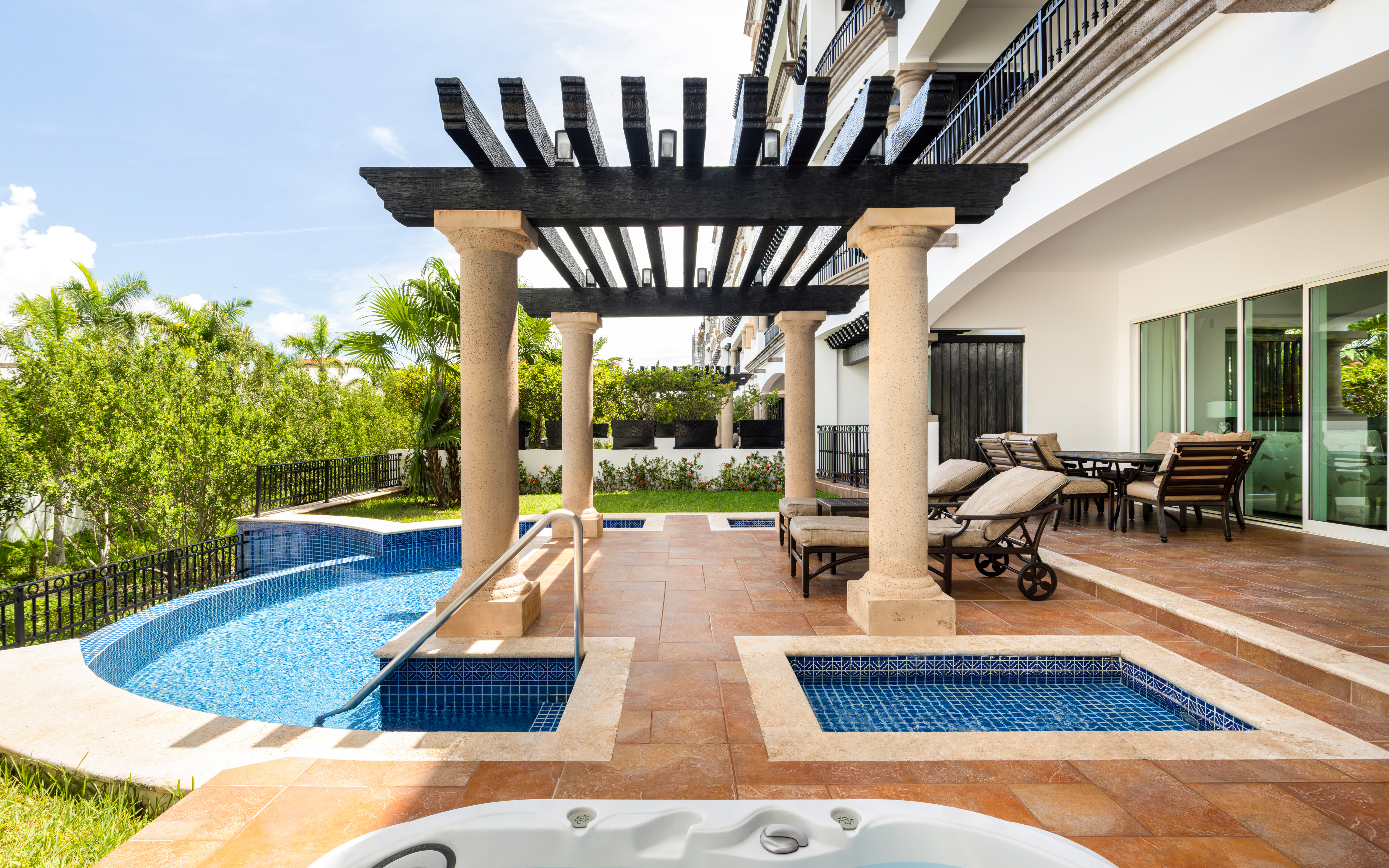 Private terrace with plunge pools, loungers, and shaded pergola.