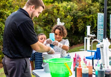 Two kids and a team member tie-dying shirts at South Beach Resort in Myrtle Beach, South Carolina