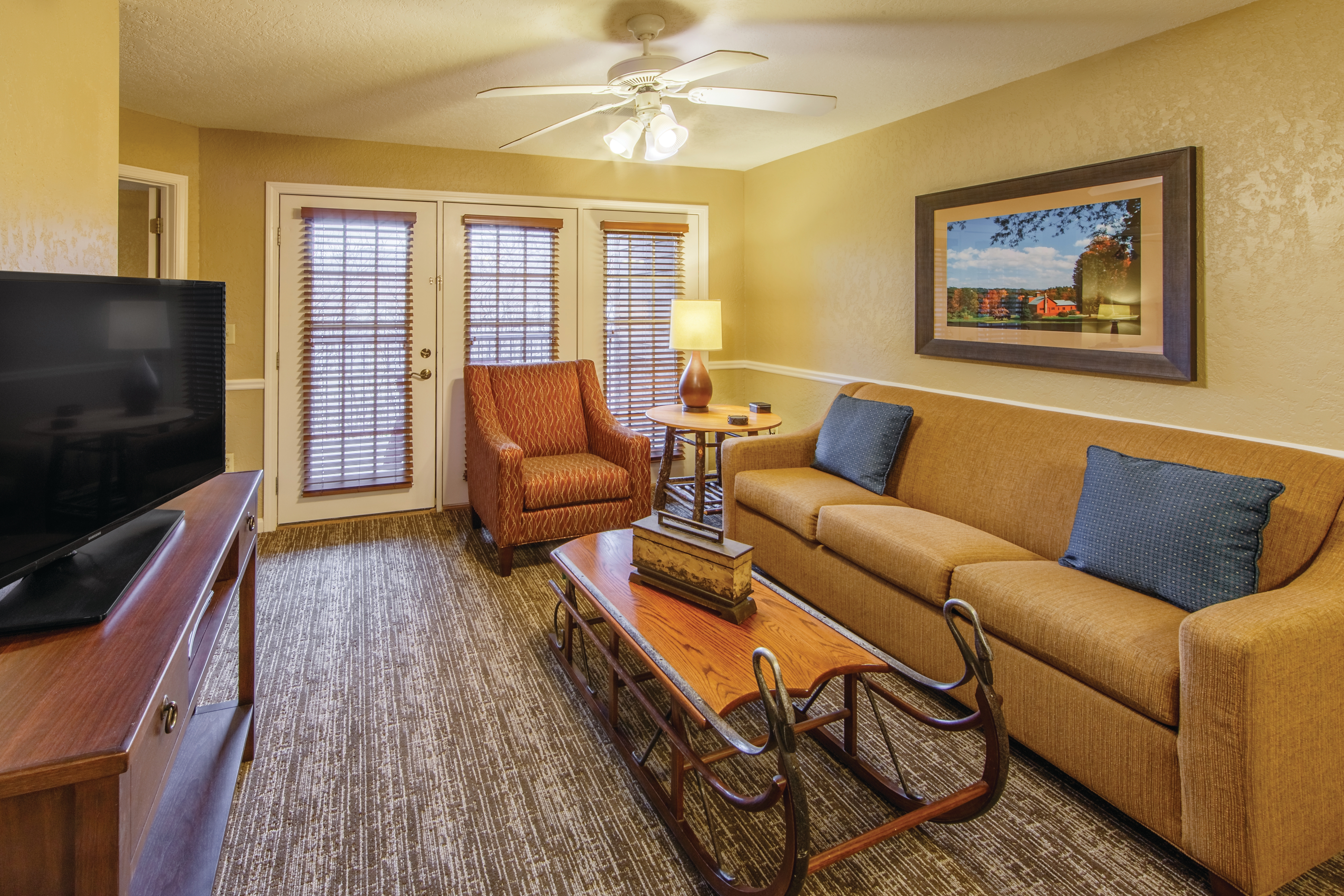 Family room with french doors leading outside in a two bedroom villa at Oak n' Spruce Resort in South Lee, Massachusetts