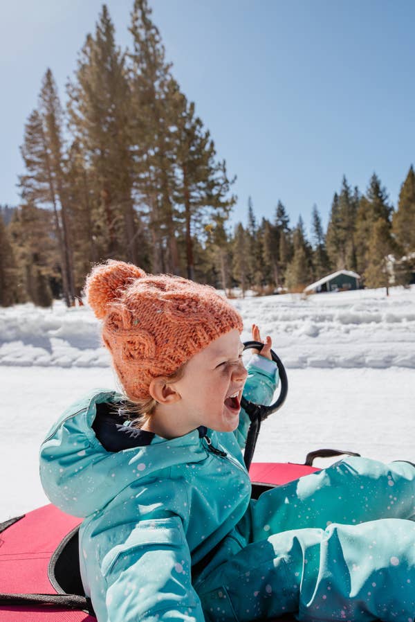 Young child riding snow tube down snowy hill near Tahoe Ridge Resort in Stateline, Nevada.