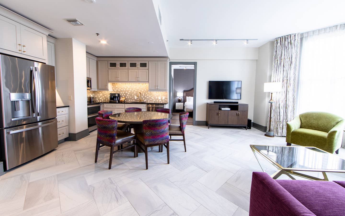 Signature Collection two bedroom villa living area with TV, dining area and full kitchen at New Orleans Resort in Louisiana.