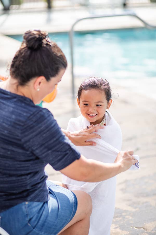 Adult wrapping child in towel outside of pool at Holiday Hills Resort in Branson, Missouri.