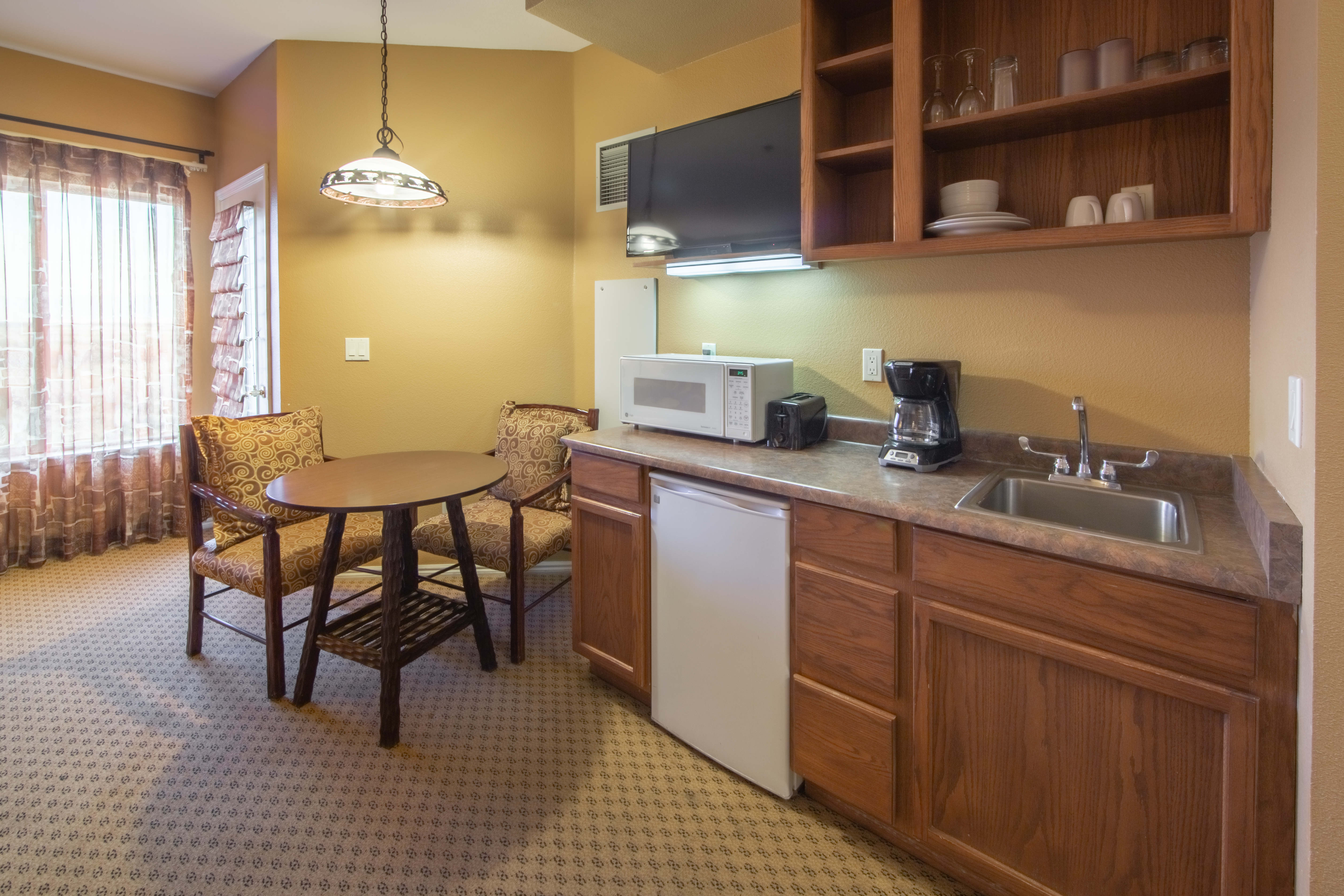 Kitchenette with microwave and mini-fridge and small dining area in a studio room at David Walley's Resort in Genoa, Nevada
