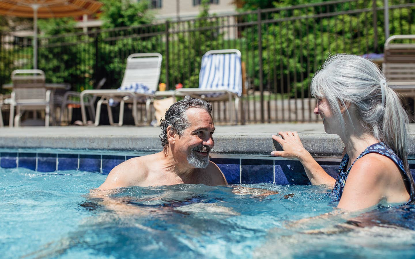 Couple sitting in outdoor pool at Oak n' Spruce Resort in South Lee, Massachusetts.