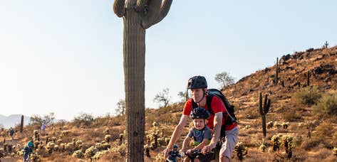Adult and child riding bike through desert near Scottsdale Resort.