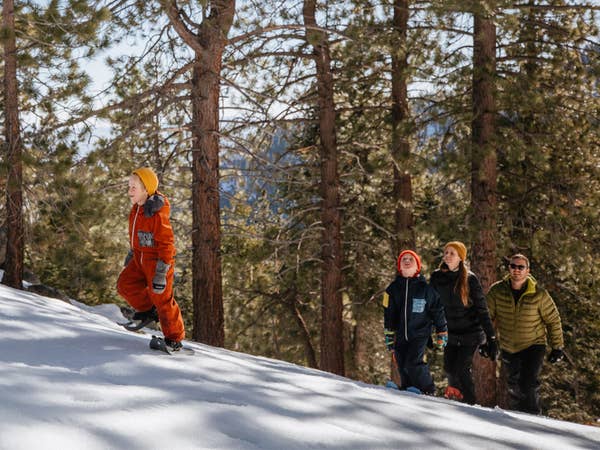 Family of four climbing snowy mountain near Tahoe Ridge Resort in Stateline, Nevada.