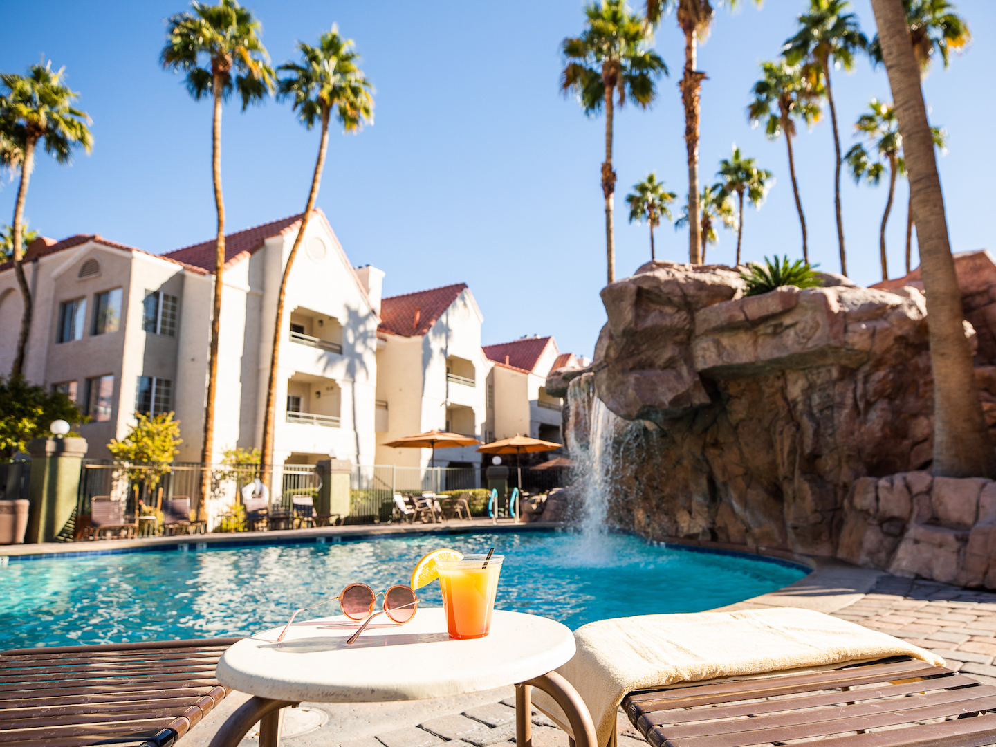 Drink by waterfall pool at Desert Club Resort in Las Vegas, Nevada.