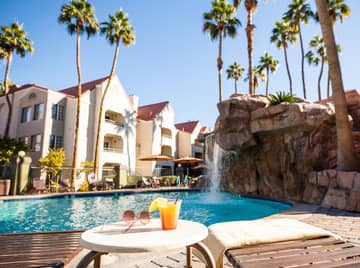 Drink by waterfall pool at Desert Club Resort in Las Vegas, Nevada.