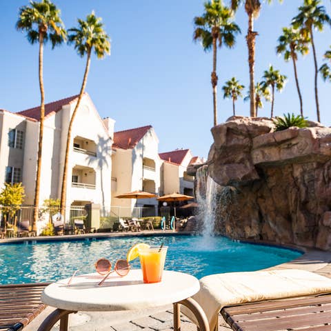 Drink by waterfall pool at Desert Club Resort in Las Vegas, Nevada.