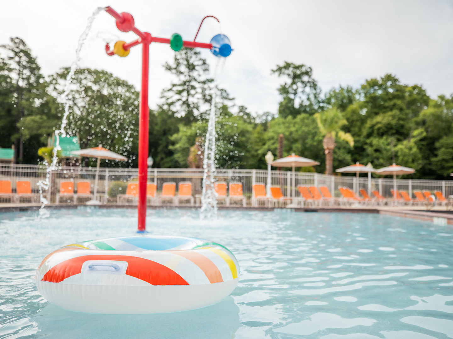 Tube floating in outdoor pool near splash buckets at Villages Resort in Flint, Texas.