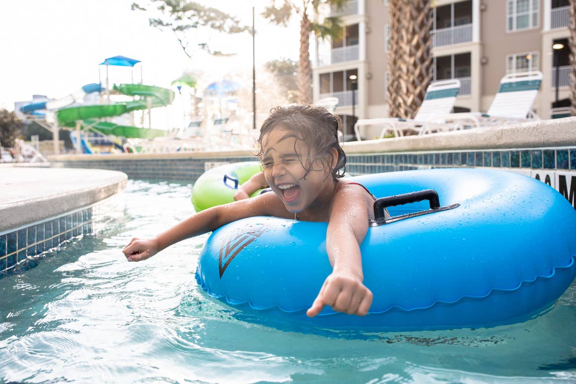 Brenda's daughter, Victoria, floats along the lazy river in a blue innertube.