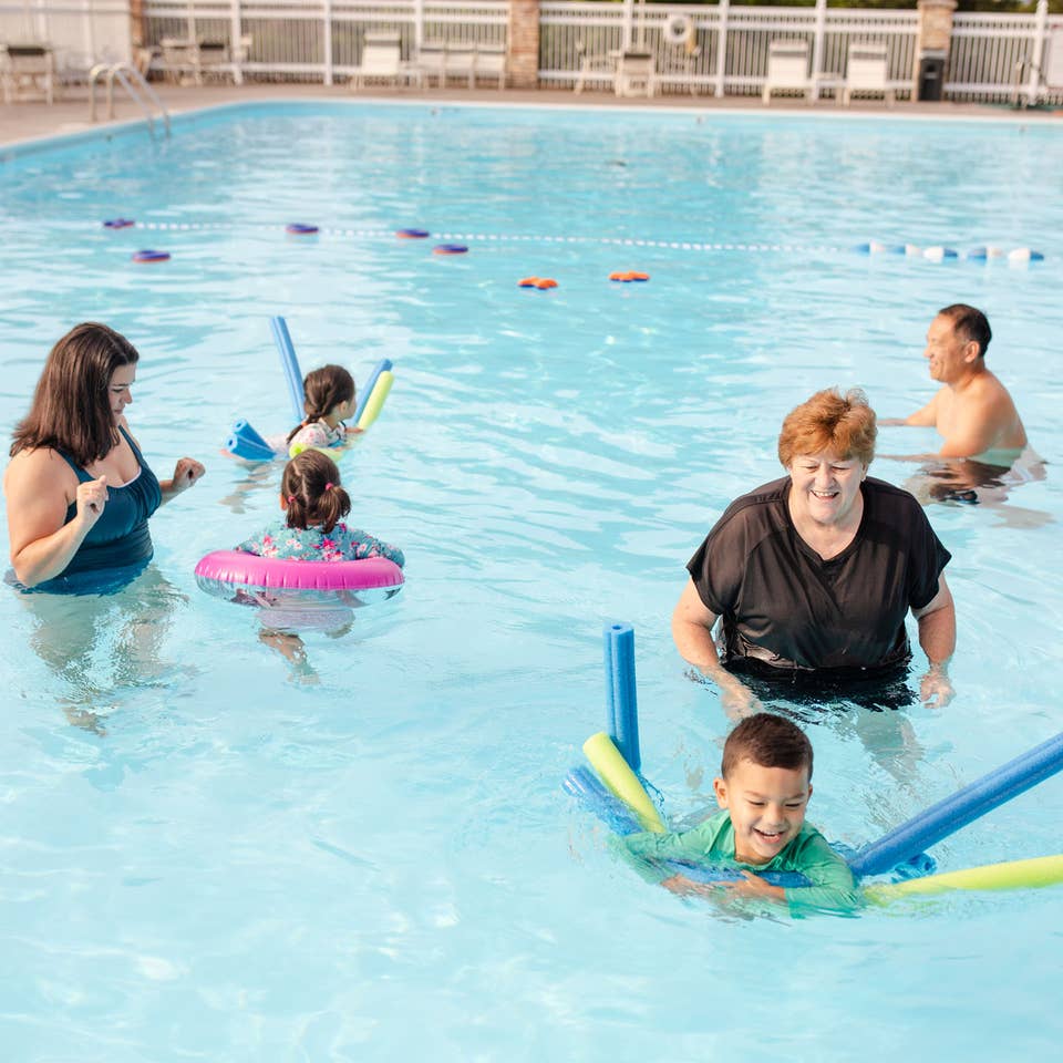 Family swimming in outdoor pool at Holiday Hills Resort in Branson, Missouri.
