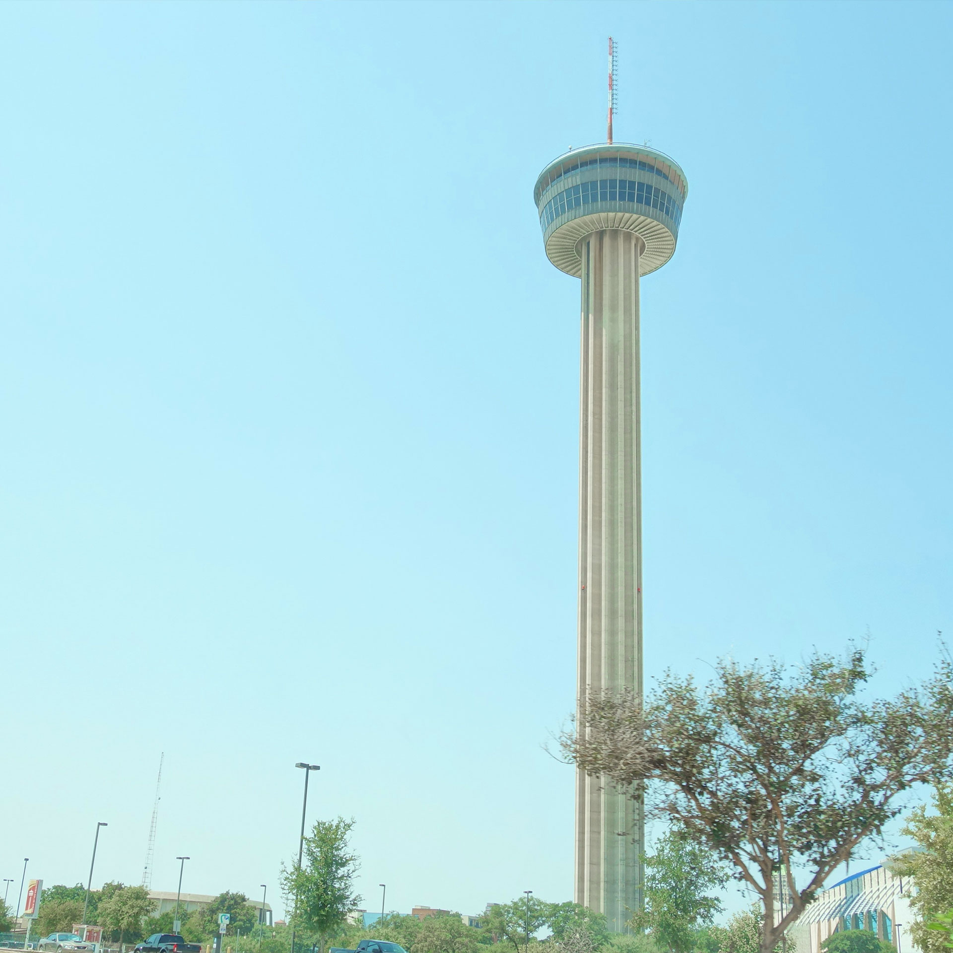A spire building overlooks a blue sky and city.