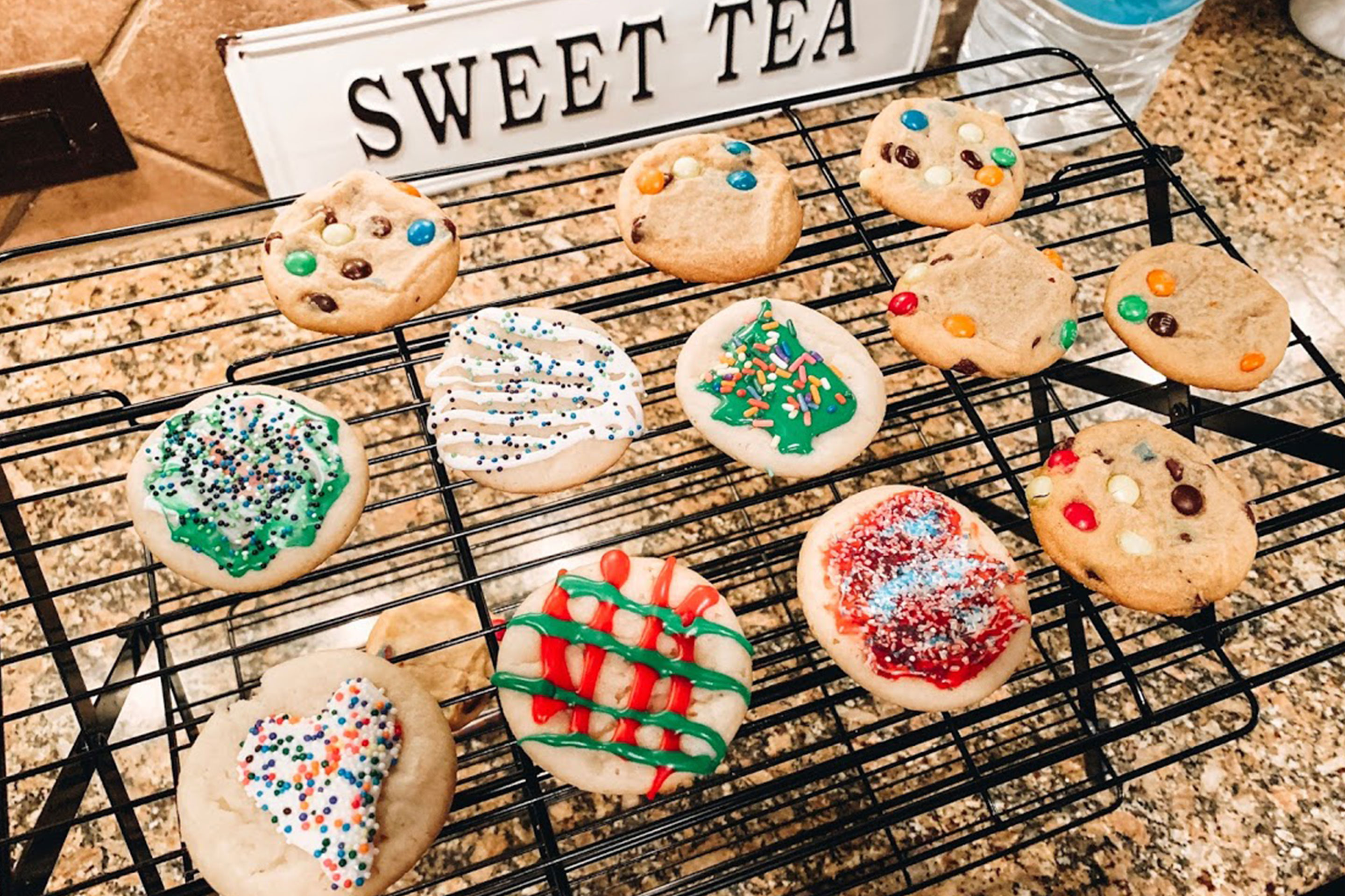 A baking rack containing sugar cookies with various icing decor.