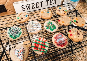 A baking rack containing sugar cookies with various icing decor.