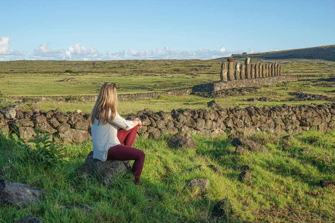 Featured Contributor, Ashlyn George, sits looking at the stone formations of Easter Island.