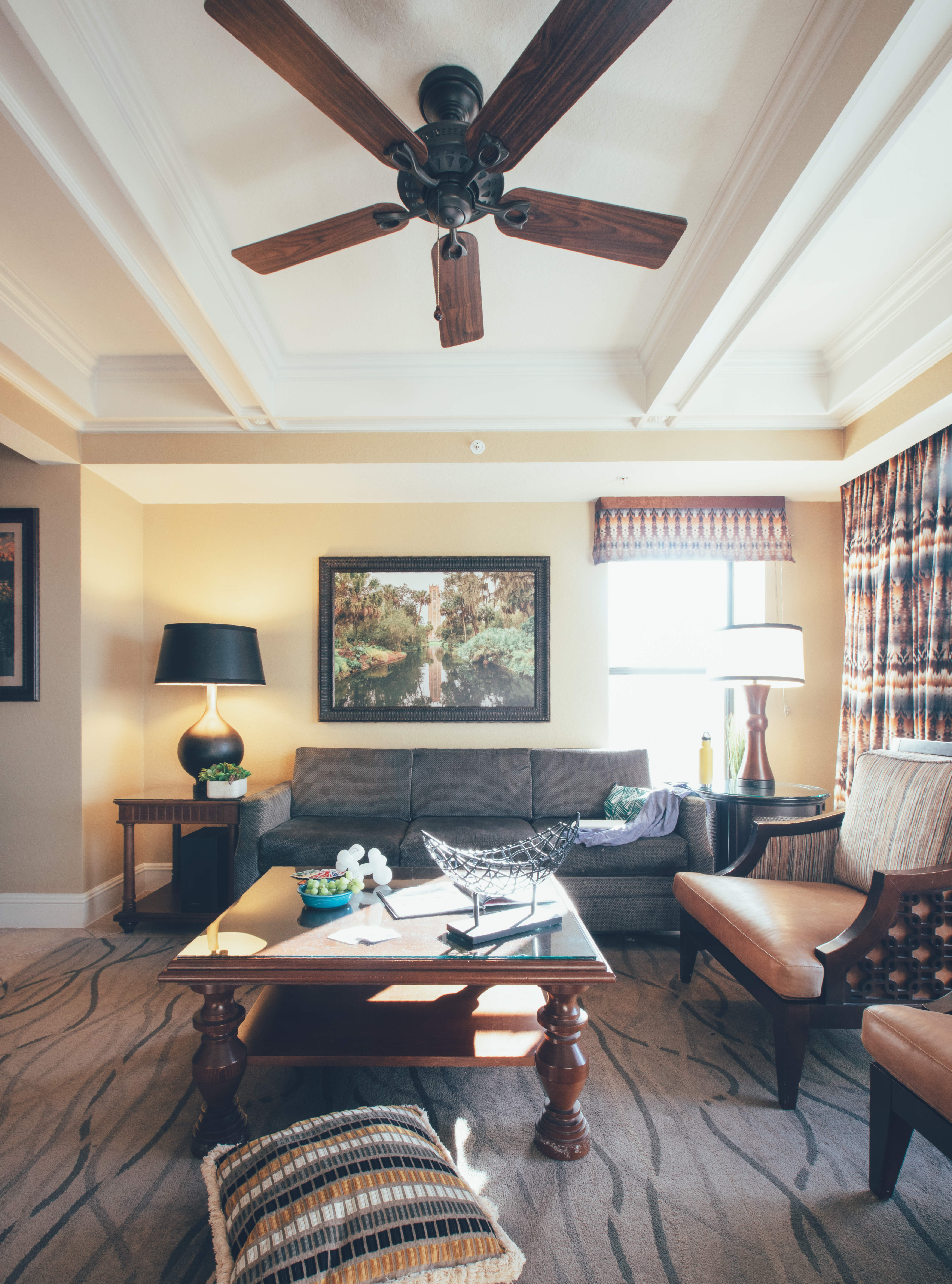 View of entire living room with ceiling fan, couch, and accent chairs in a Signature villa in River Island at Orange Lake Resort near Orlando, Florida