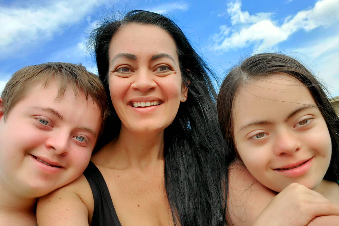 De izquierda a derecha: un niño está junto a una señora y una niña bajo un cielo azul.