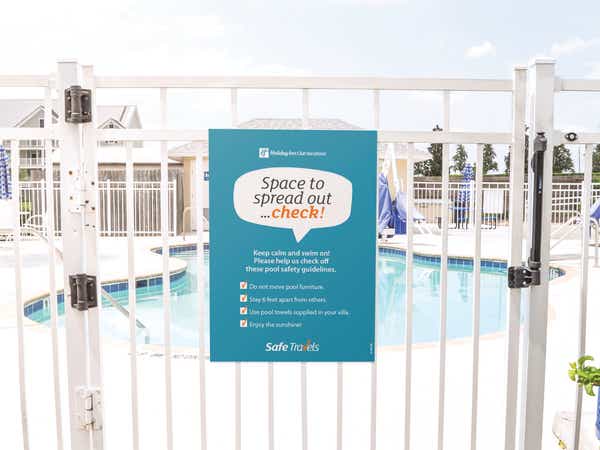 Safe Travels sign on the gate at a pool at a resort
