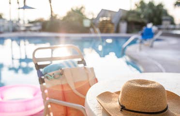 Jennifer's hat sits on a table with swimwear next to the poolside of a Holiday Inn Club Vacation Resort.
