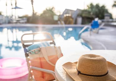 Jennifer's hat sits on a table with swimwear next to the poolside of a Holiday Inn Club Vacation Resort.