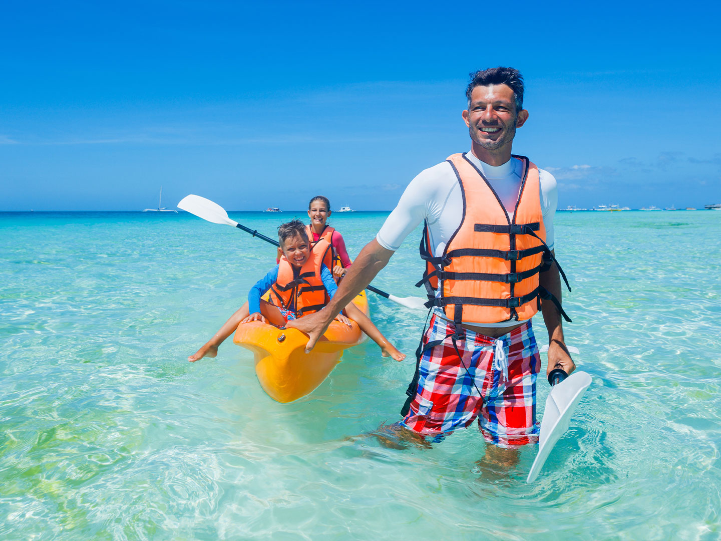 Family doing canoe on the beach at Royal Resorts in Mexico.