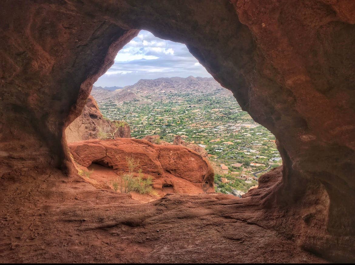 A view of the Arizona landscape through the “window” formation in the rocks on the Camelback Mountain summit.