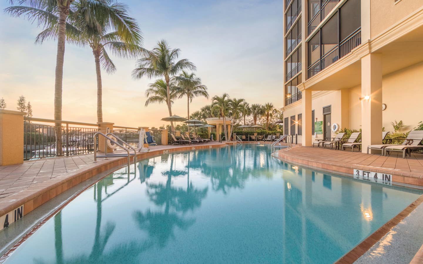 Outdoor pool surrounded by palm trees at Sunset Cove Resort