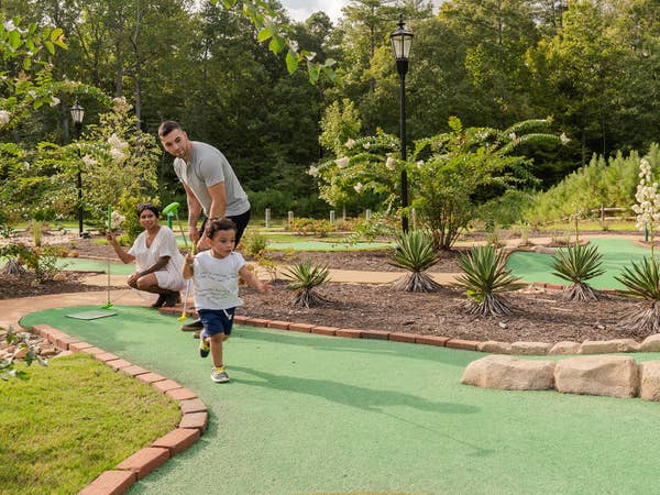 Family playing mini golf.