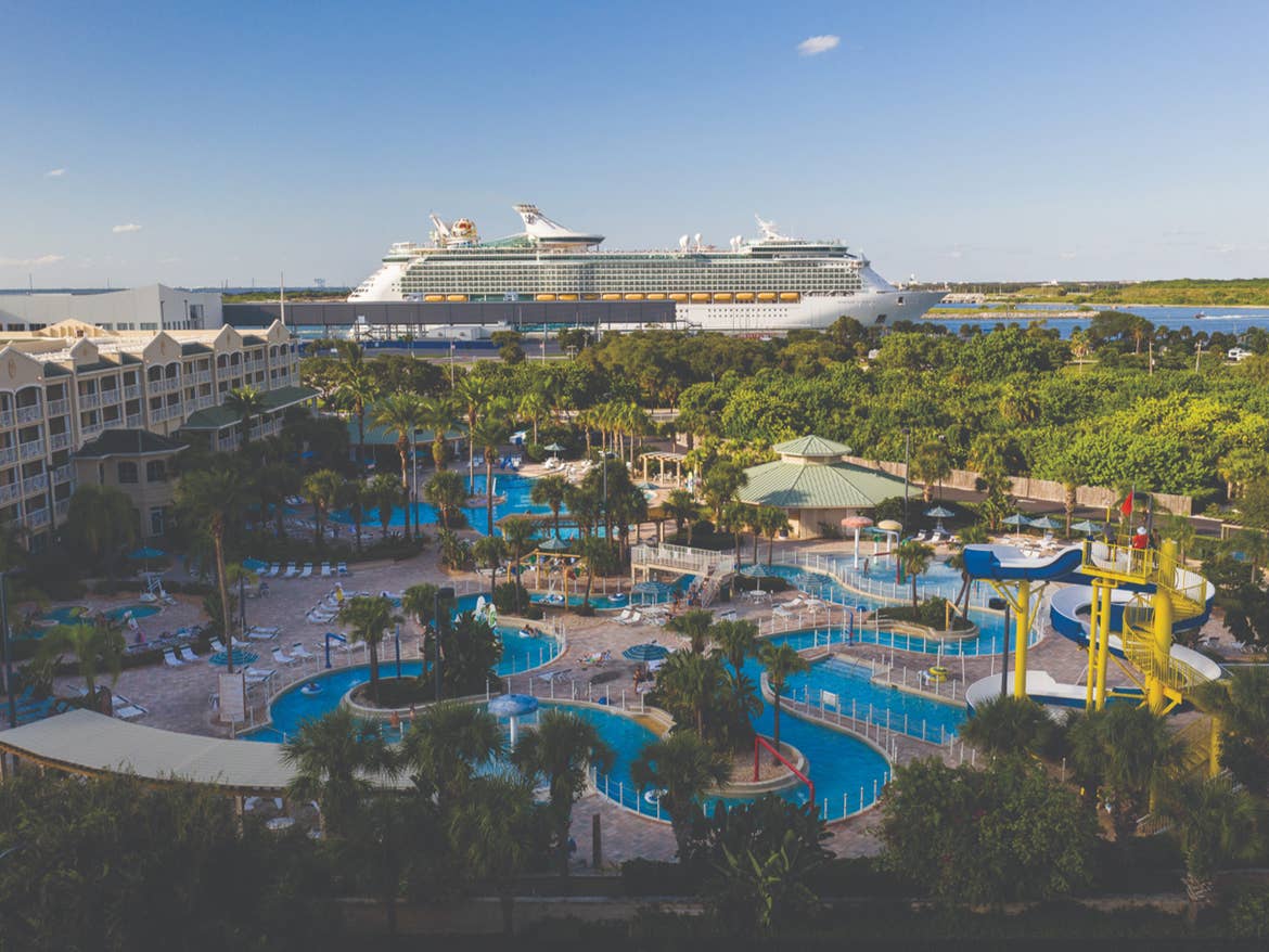 Historic Pensacola lighthouse near white sand beach and clear water.