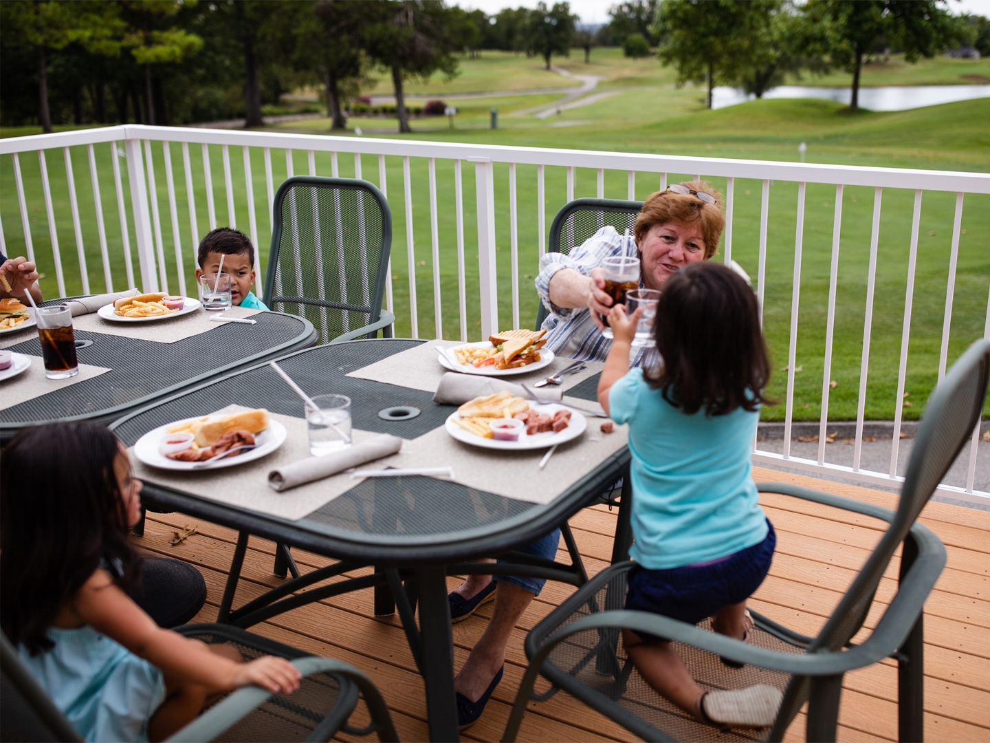 Family eating outdoors at The Grille on the Greens at Holiday Hills Resort in Branson, Missouri.