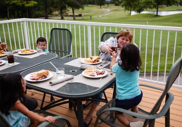 Family eating outdoors at The Grille on the Greens at Holiday Hills Resort in Branson, Missouri.
