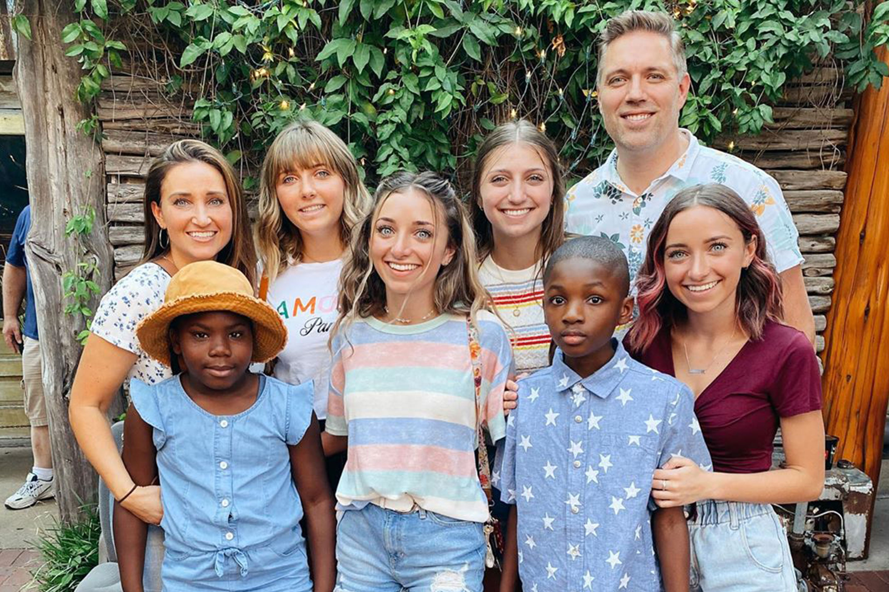 Mindy and her family pose in outdoors.