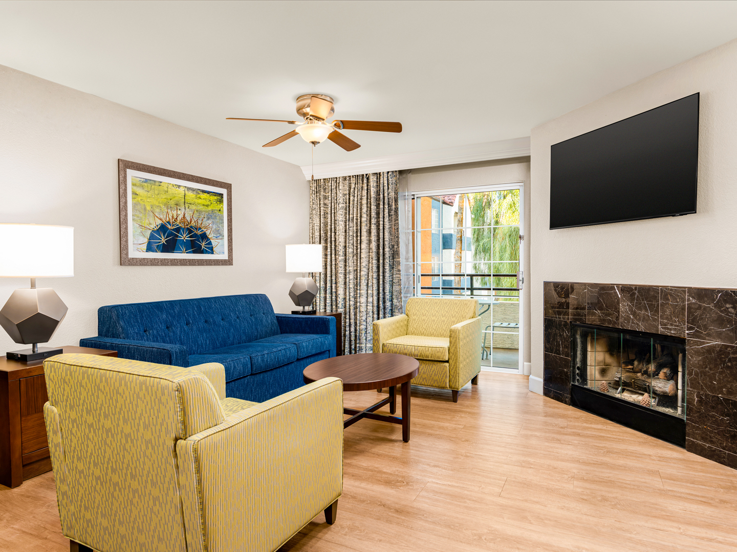 Bright living area with fireplace, balcony access, and modern decor.
