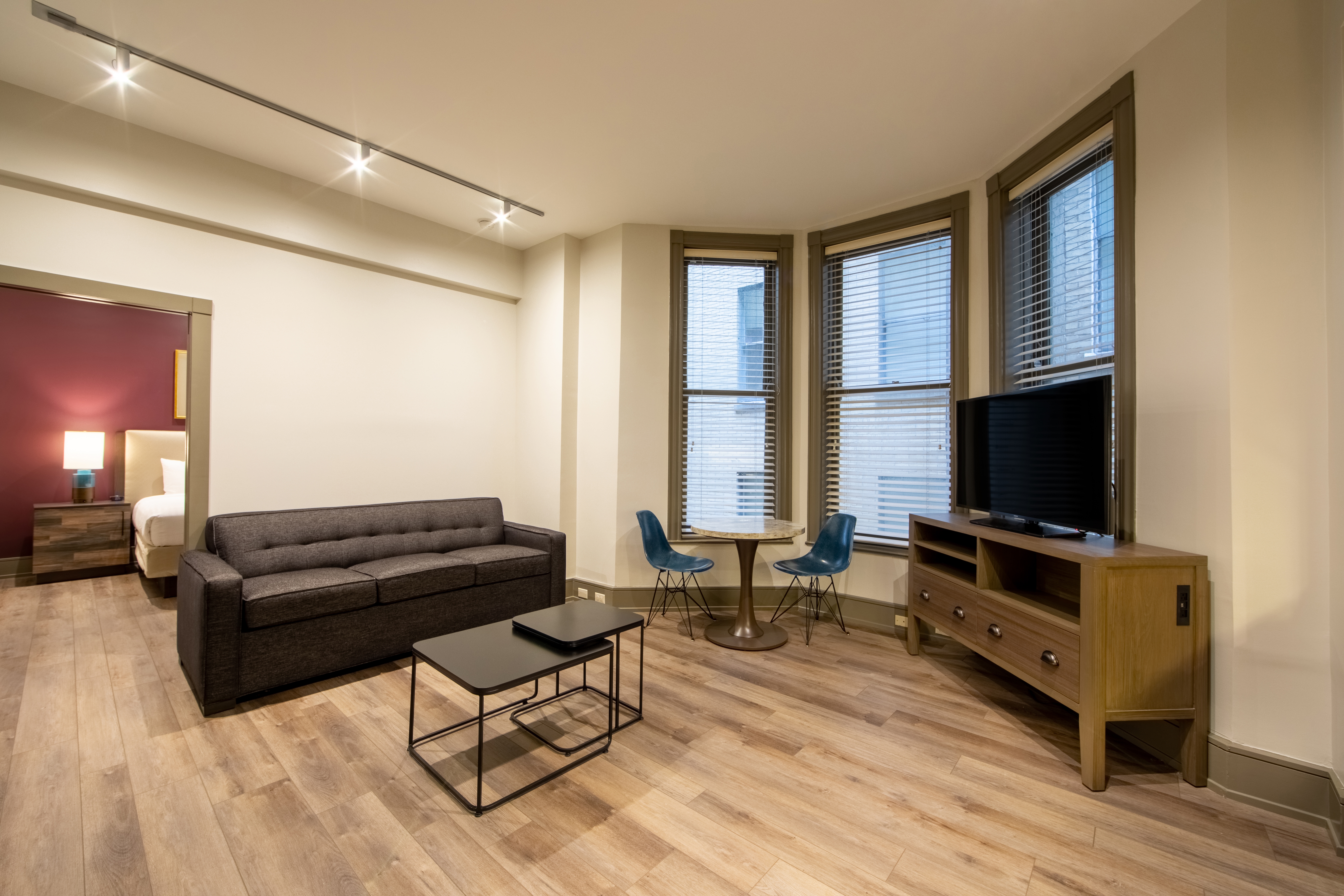 One bedroom villa living room with couch, three windows and TV at New Orleans Resort in Louisiana.
