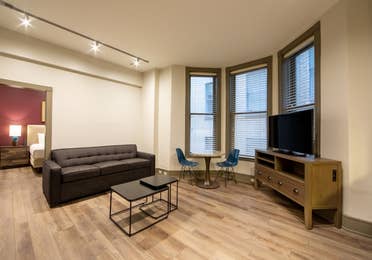 One bedroom villa living room with couch, three windows and TV at New Orleans Resort in Louisiana.