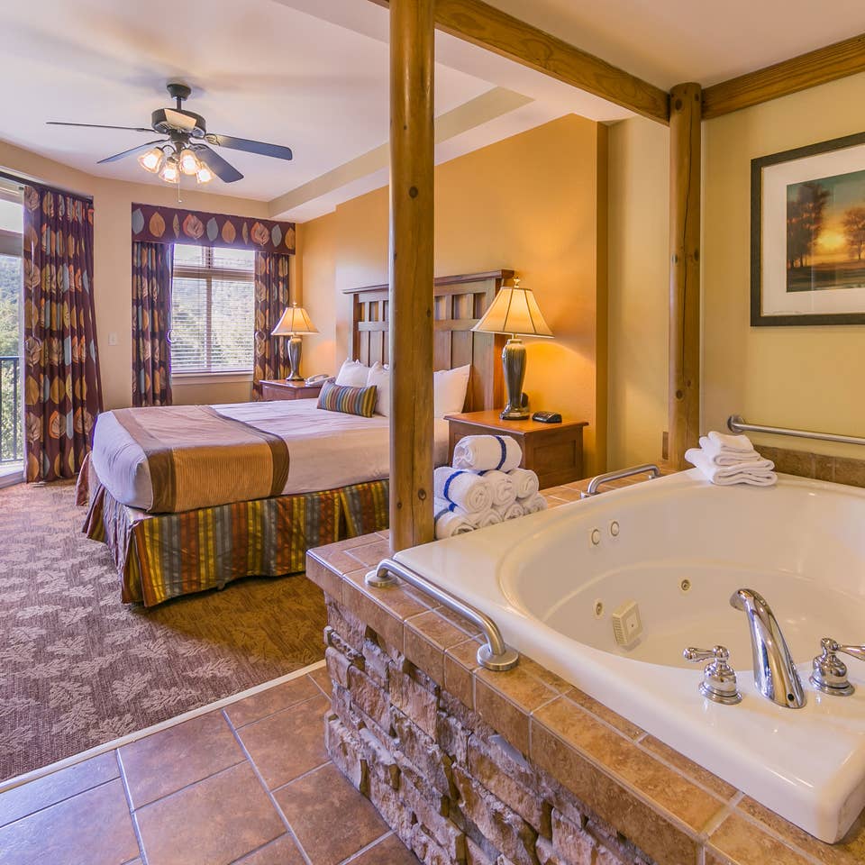 Bedroom with a bed and jacuzzi tub at Smoky Mountain Resort in Gatlinburg, Tennessee.