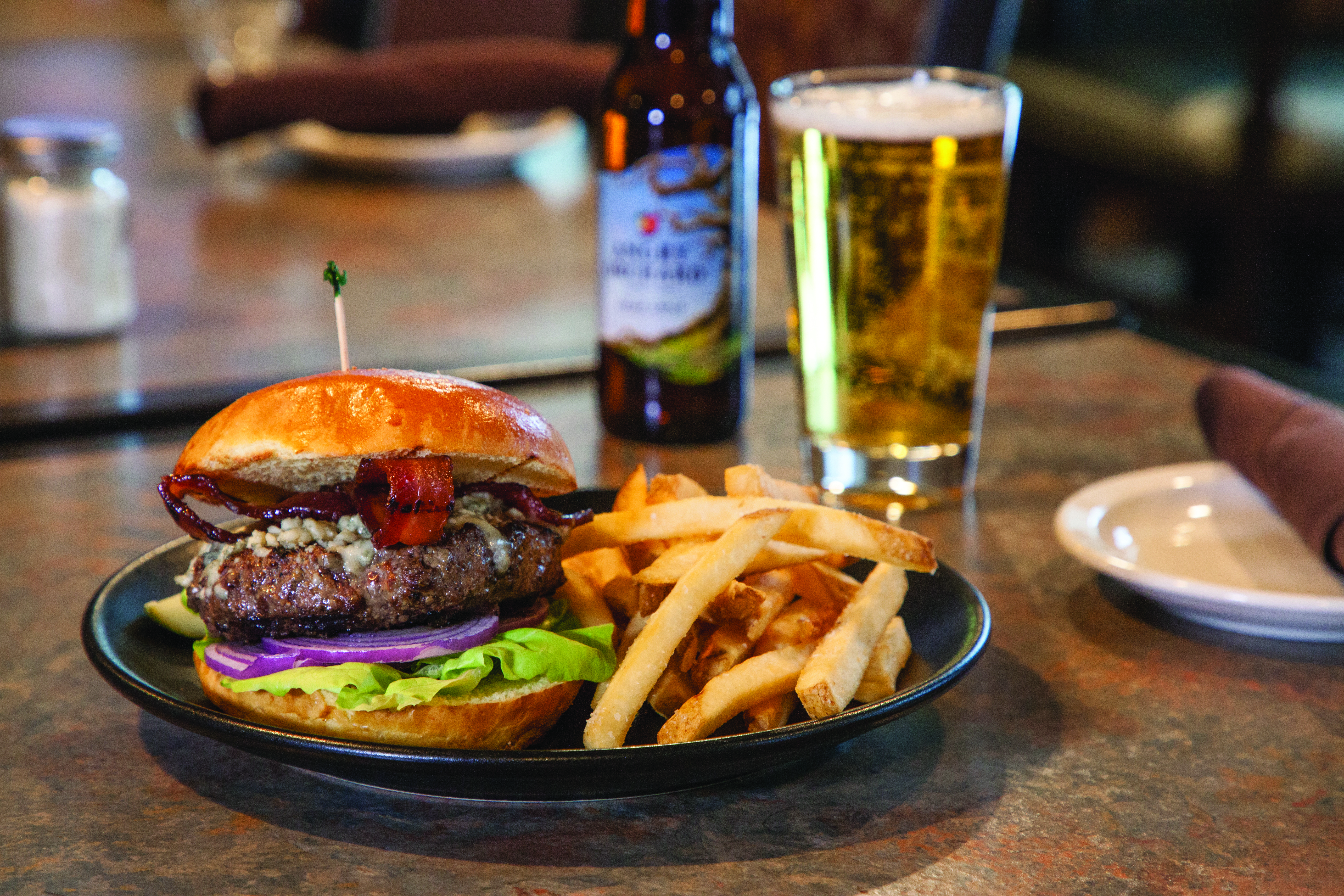 A hamburger, french fries and hard cider in a glass from The Maple Kitchen at Mount Ascutney Resort